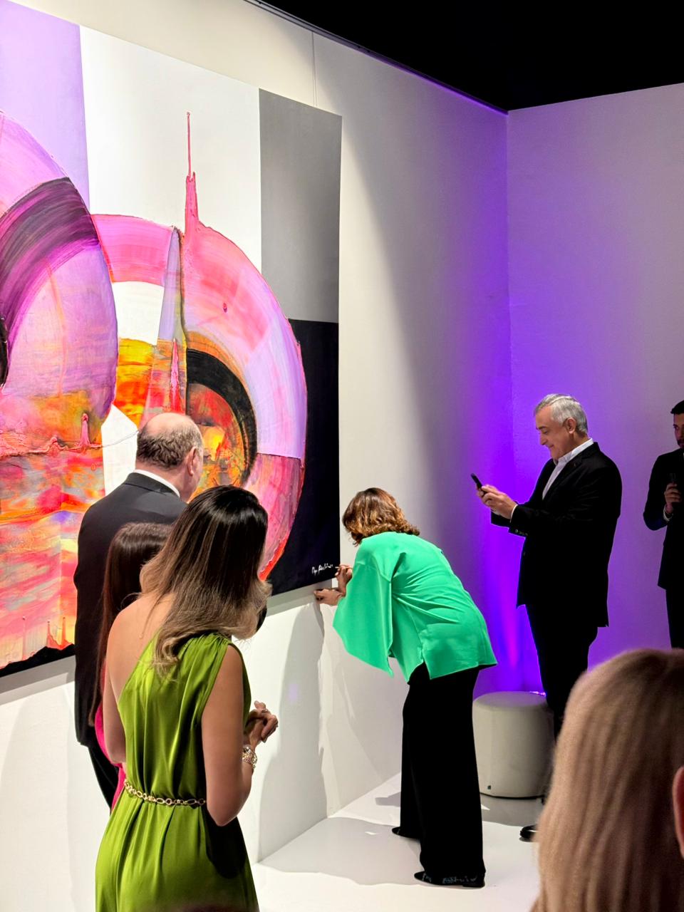 Olga Sincliar firmando el cuadro de su autoria